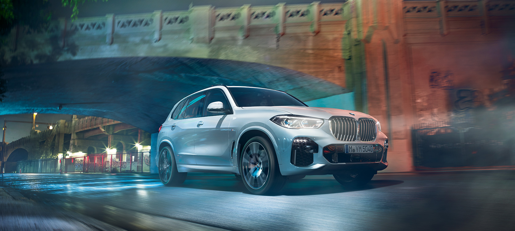 BMW X5 G05 2021 en Mineralweiß metallic vue de trois quarts avant en marche, de nuit