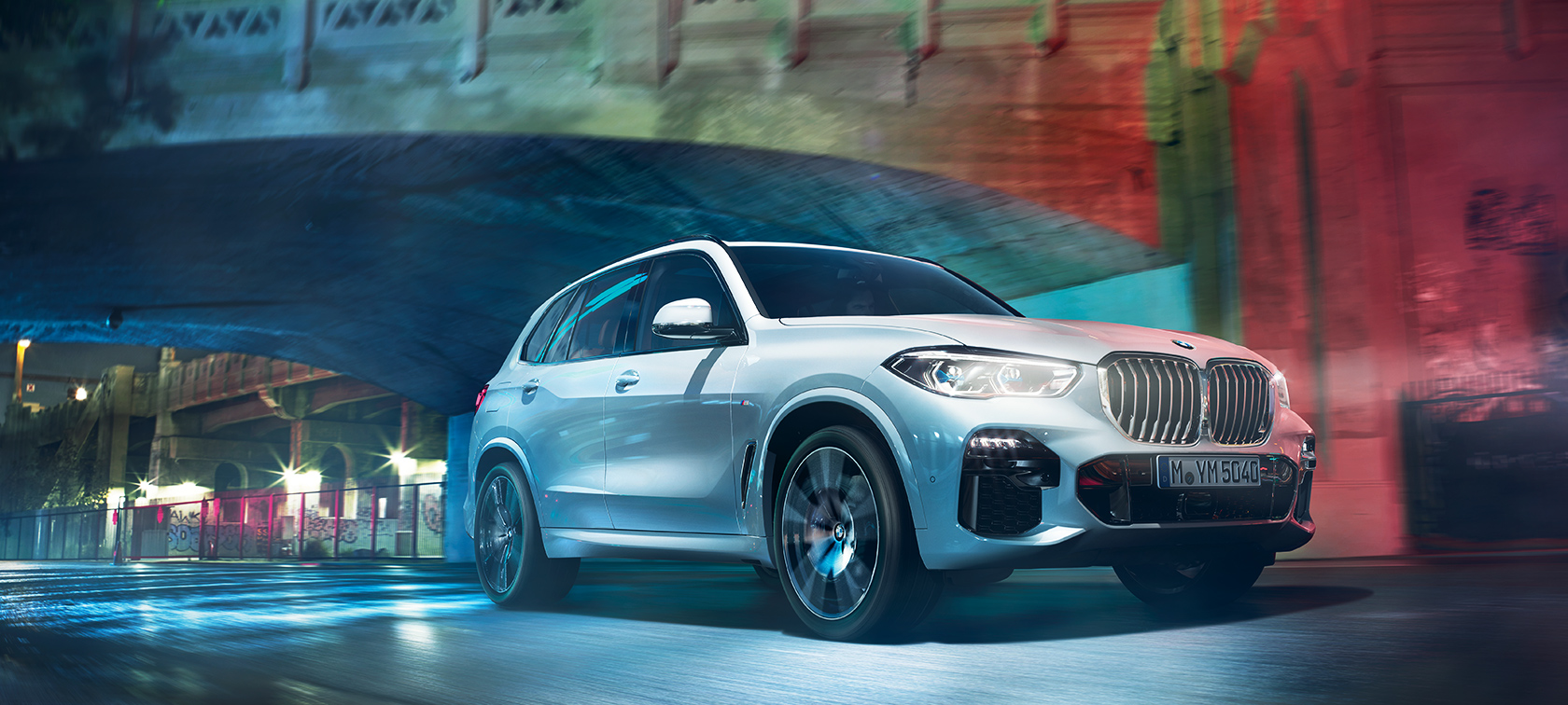 BMW X5 G05 2021 en Mineralweiß metallic vue de trois quarts avant en marche, de nuit