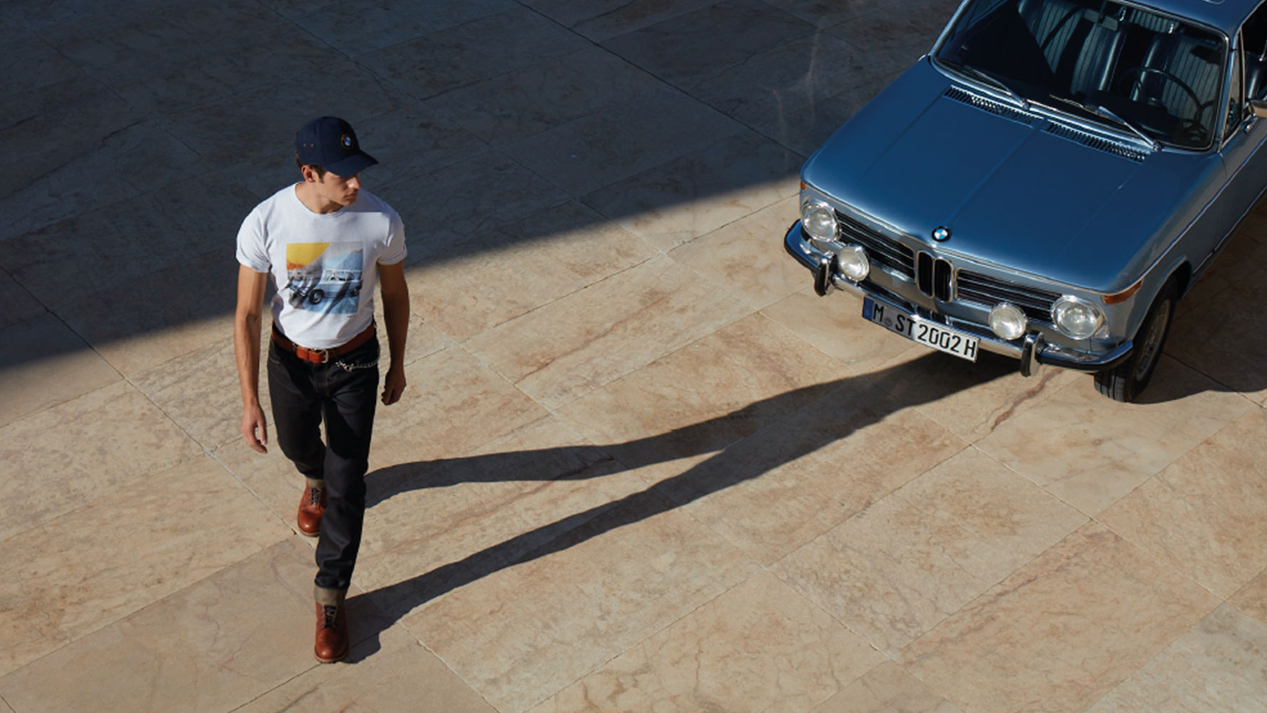 Un homme, portant un T-shirt pour homme BMW Classic issu de la collection BMW Classic, admire une oldtimer BMW. Un homme, portant un T-shirt pour homme BMW Classic issu de la collection BMW Classic, admire une oldtimer BMW.