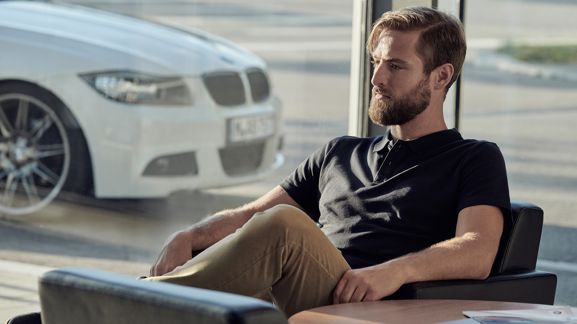 BMW Service BMW Serenity BMW Service BMW Serenity Un homme assis en toute décontraction chez un concessionnaire BMW
